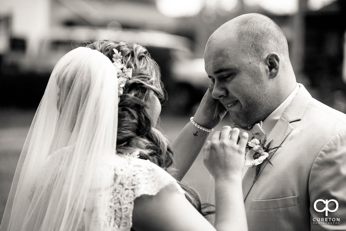 Bride wiping a tear from her groom's eye before the ceremony at The Grove at Pennington.