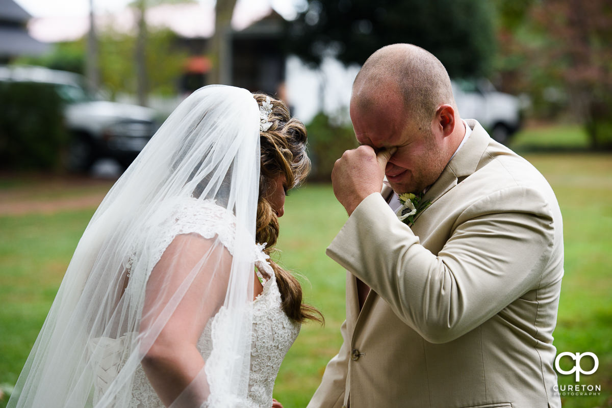 Groom tearing up at the first look.