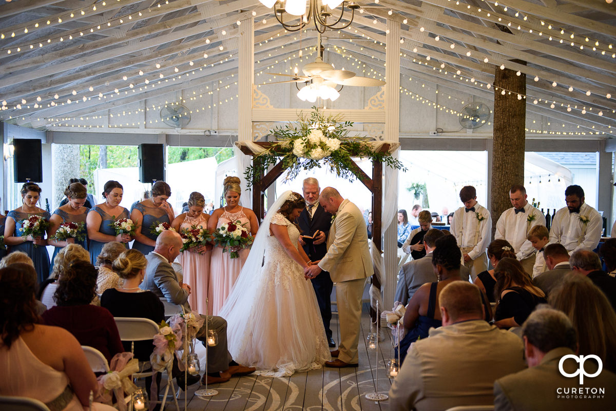 Bride and groom praying at their wedding ceremony.