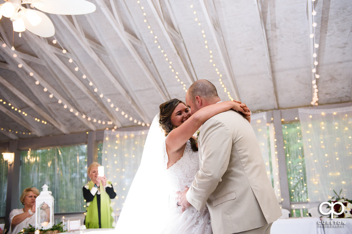 Bride laughing with her groom during their first dance.