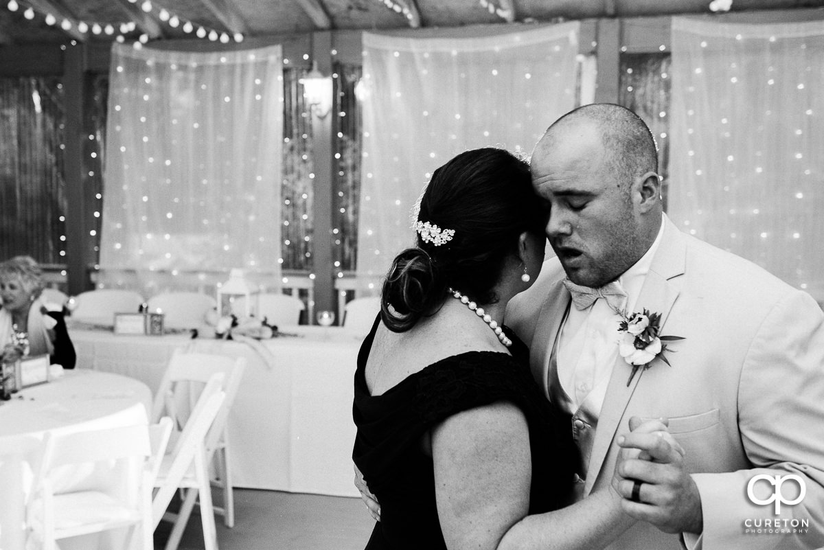 Emotional groom dancing with his mother at the reception.
