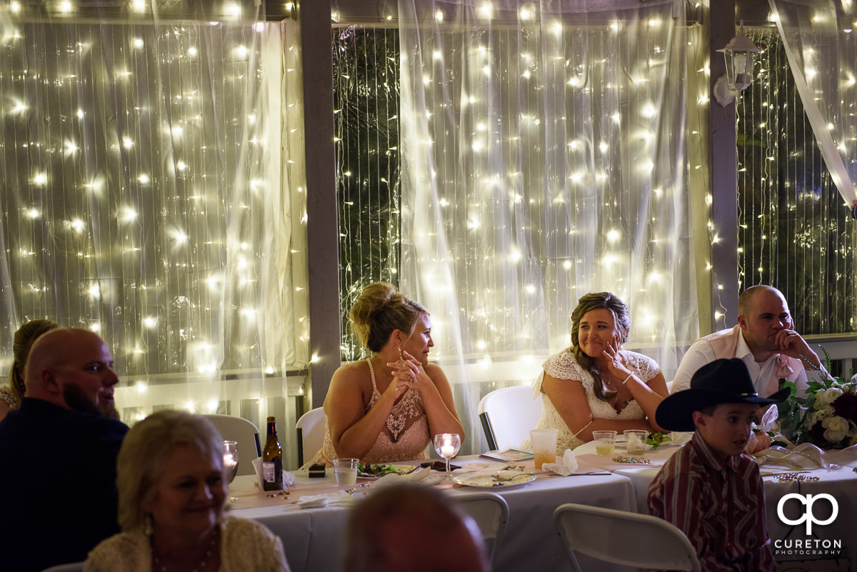 Bride getting emotional during a slideshow at the reception.