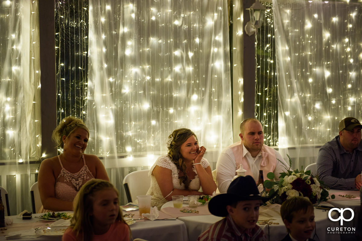 Bride and groom watching a slideshow at the reception.