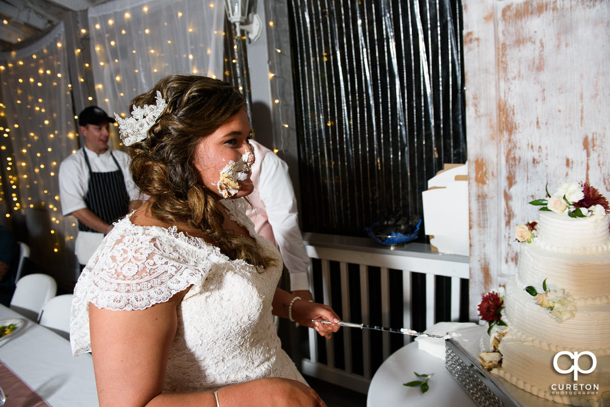 Bride with cake on her face.