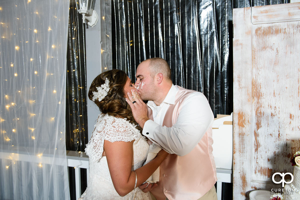 Bride and groom kissing after the cake cutting.