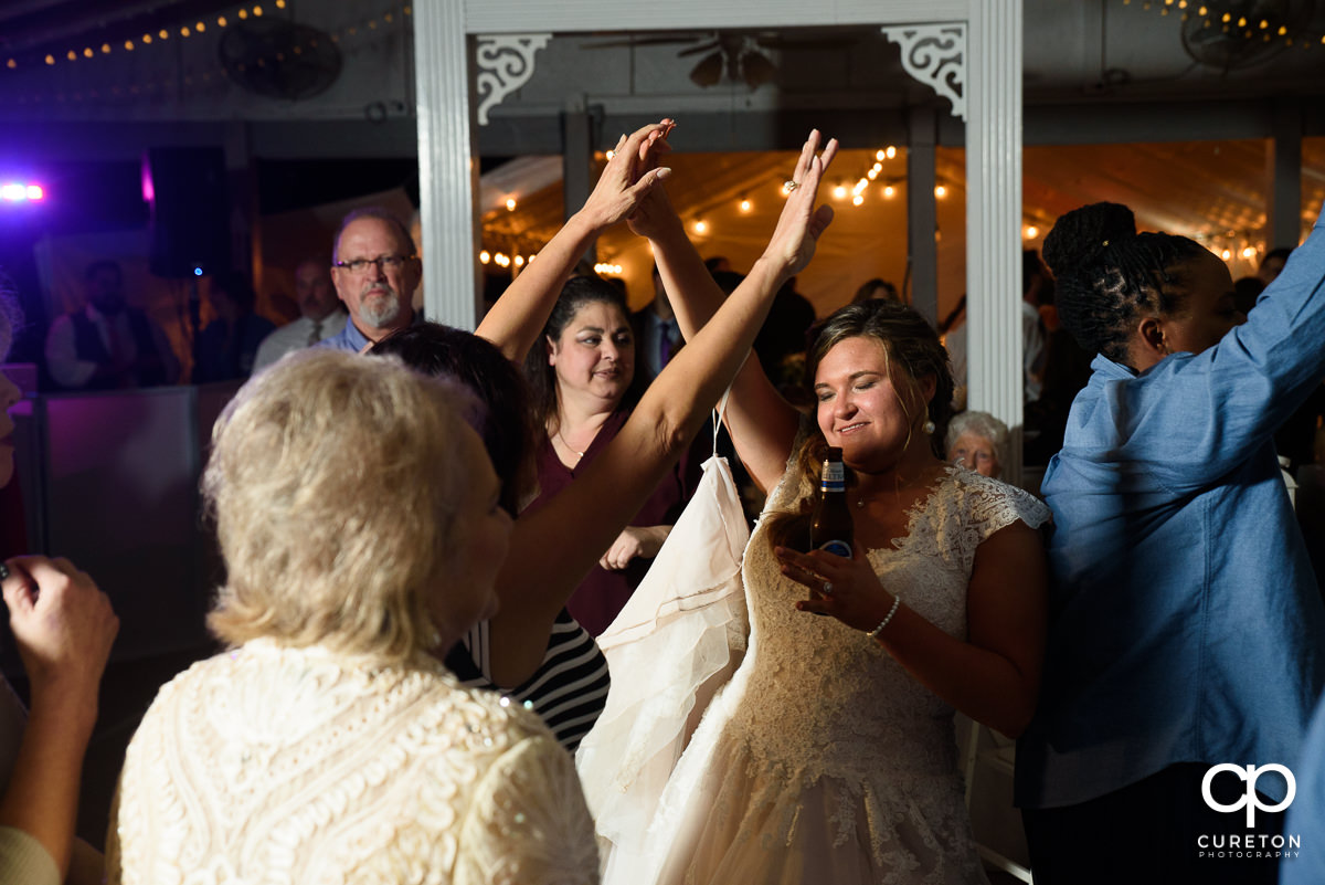 Wedding guests dancing with the bride at the reception.