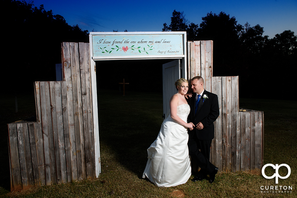 Bride and groom posing by the doors outside the hollow at Paris mountain.