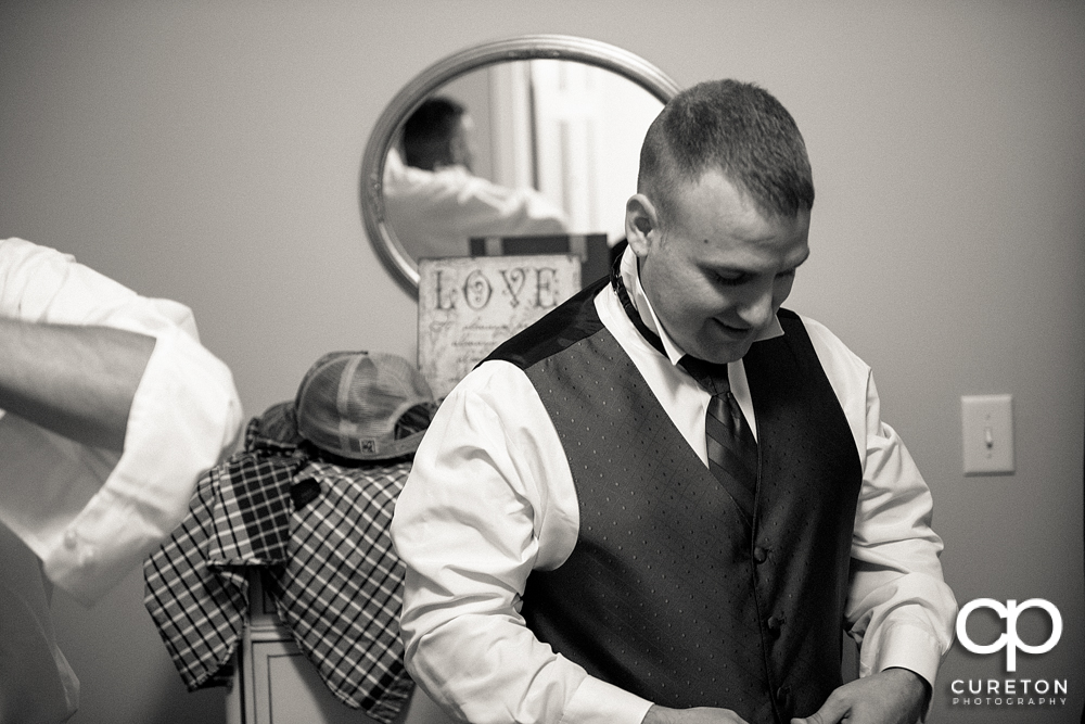 The groom putting his tux on.