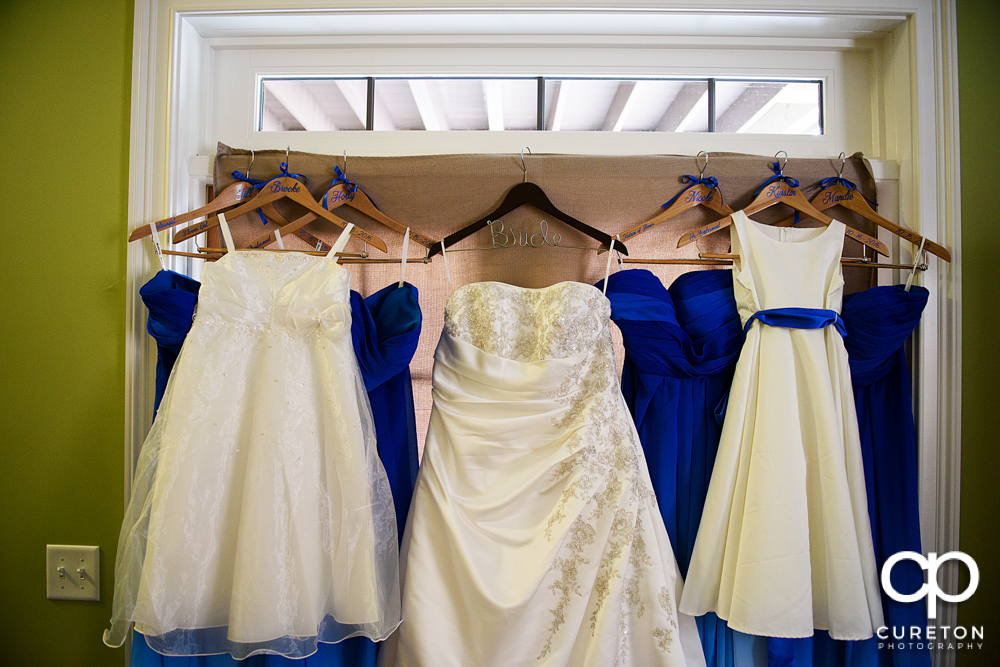 The bride and bridesmaid's dresses hanging up.