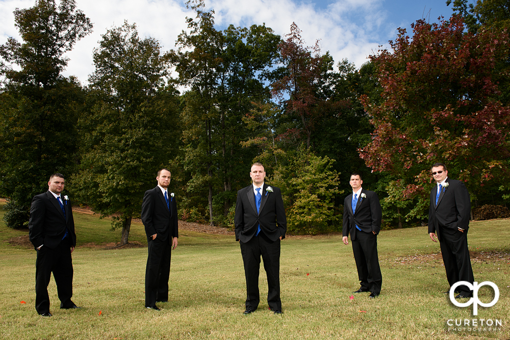 The groomsmen standing in a field.