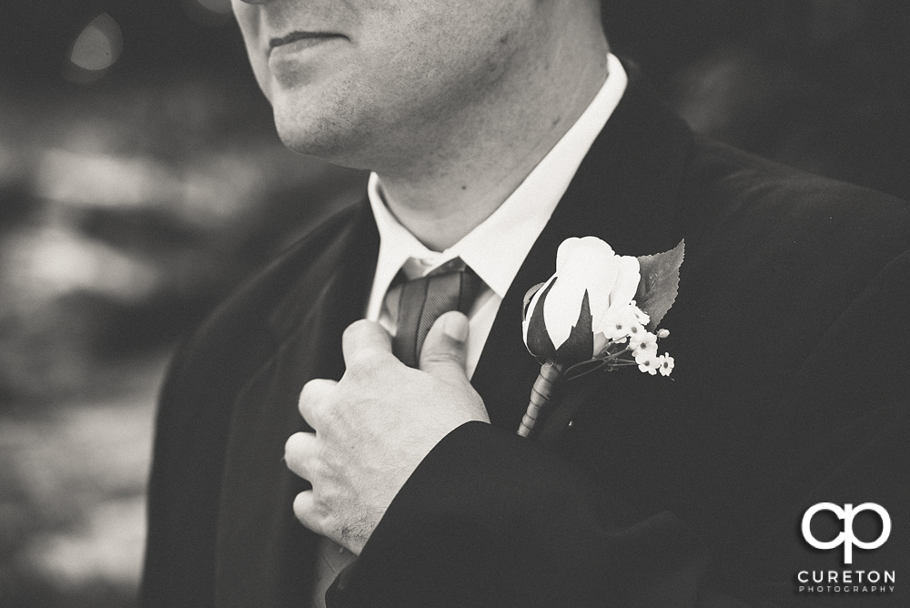 The groom adjusting his tie.