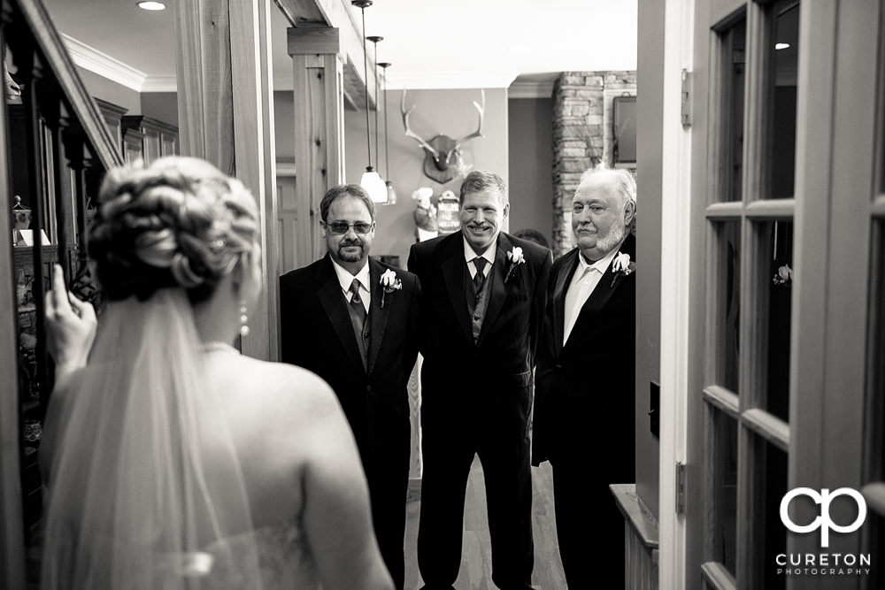 Bride having a first look with her dads.