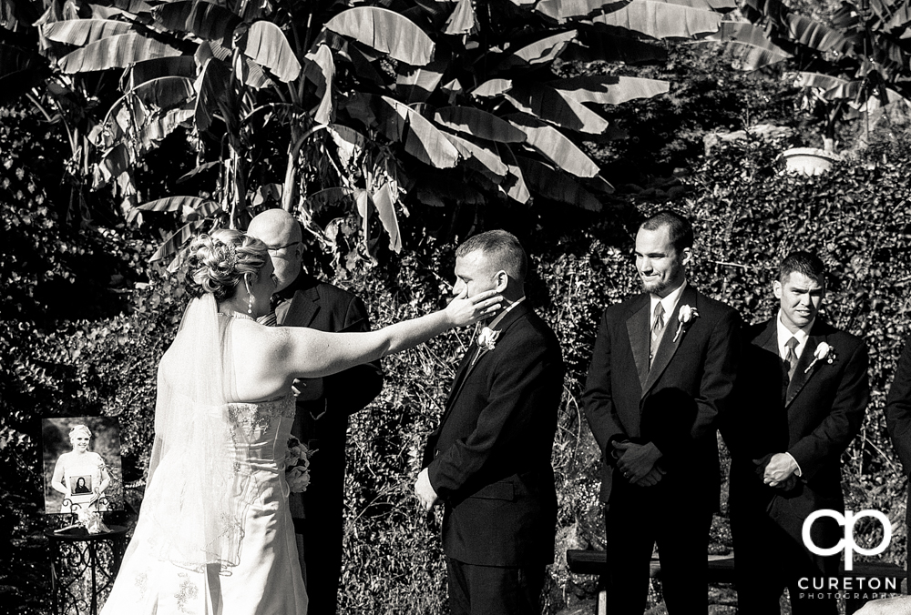 Bride wiping a tear from the groom's eye.