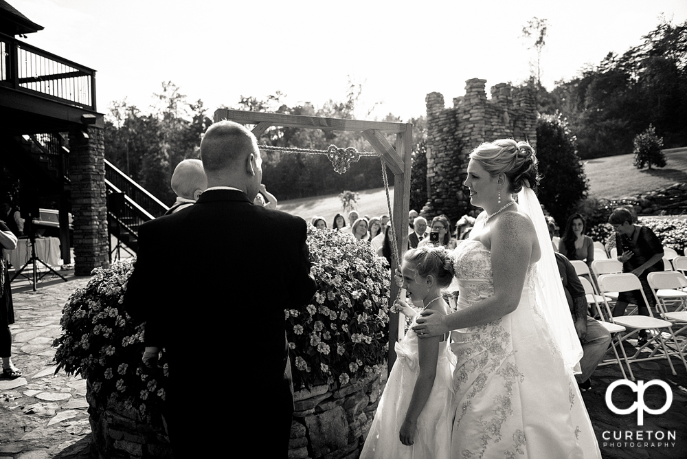 Bride and groom tying a knot in a rope during their wedding ceremony.