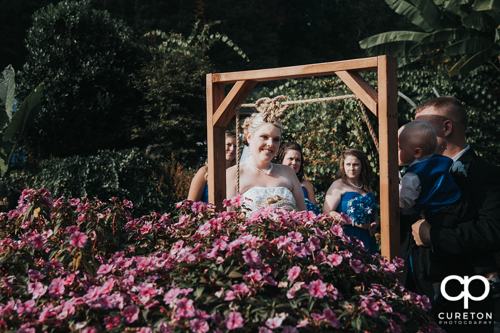 Bride and groom tying a knot in a rope during their wedding ceremony.