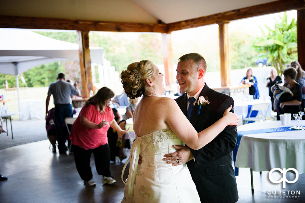 Bride and groom laughing during their first dance.