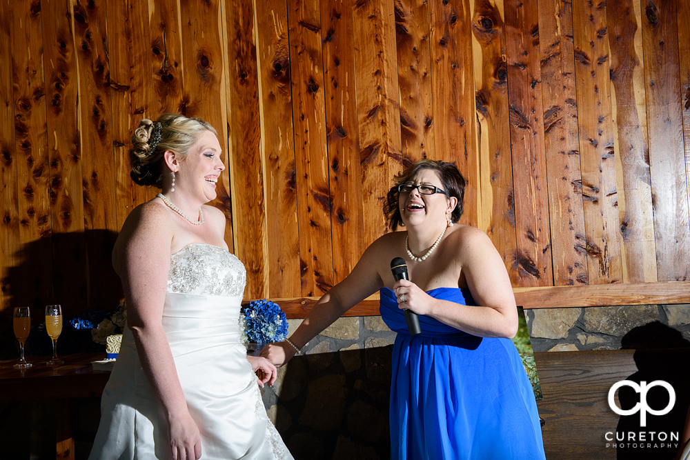 Bride and bridesmaid laughing.
