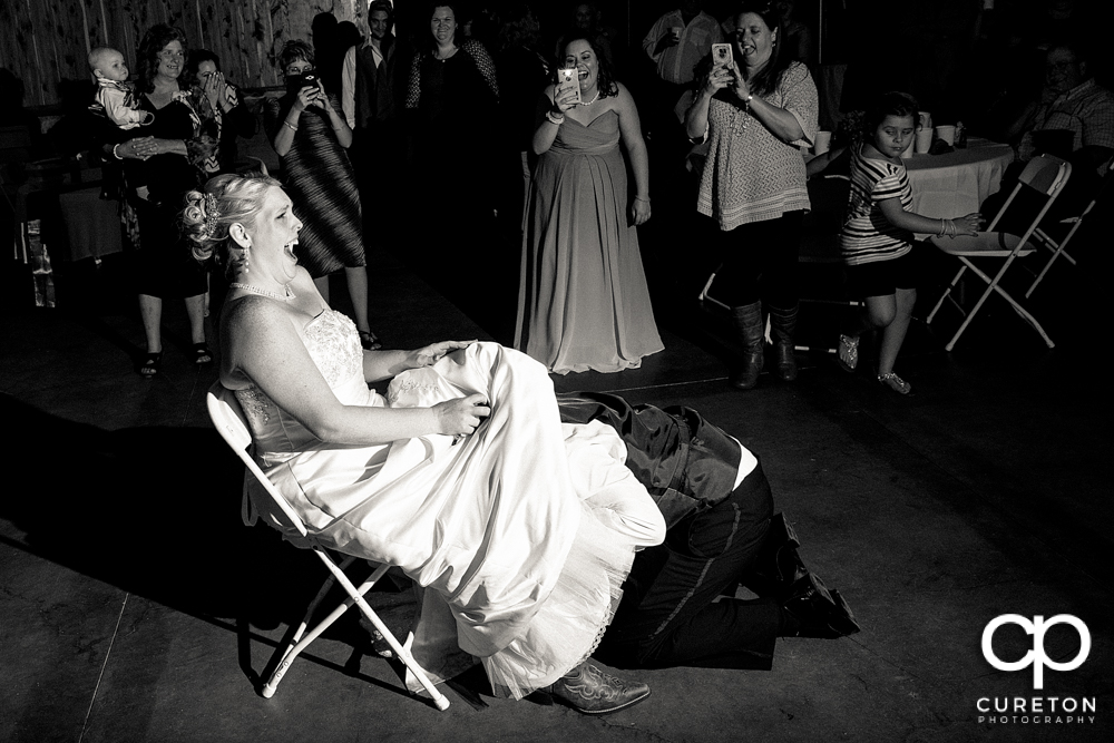 Groom taking the garter off.