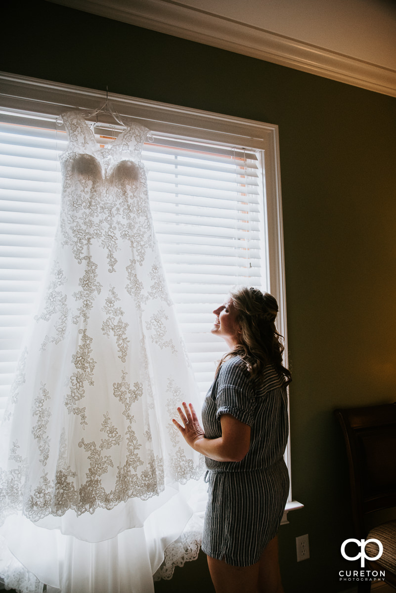 Bride looking up at her dress in the window.