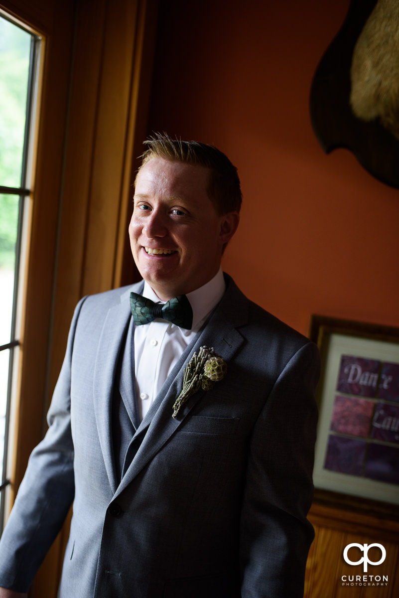 Groom smiling in the window.