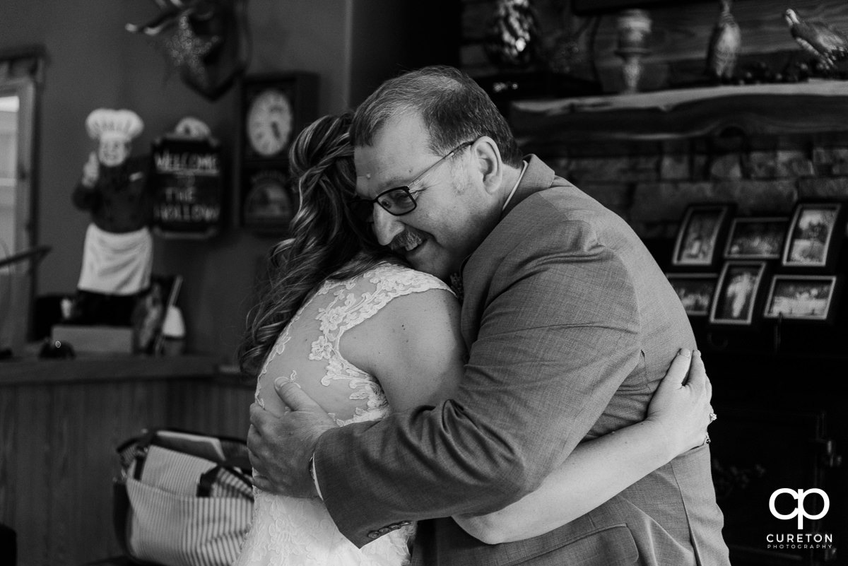 Bride hugging her father when he sees her before the wedding ceremony.