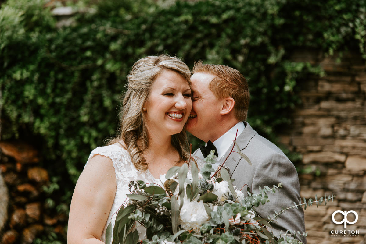 Groom whispering in his bride;s ear.