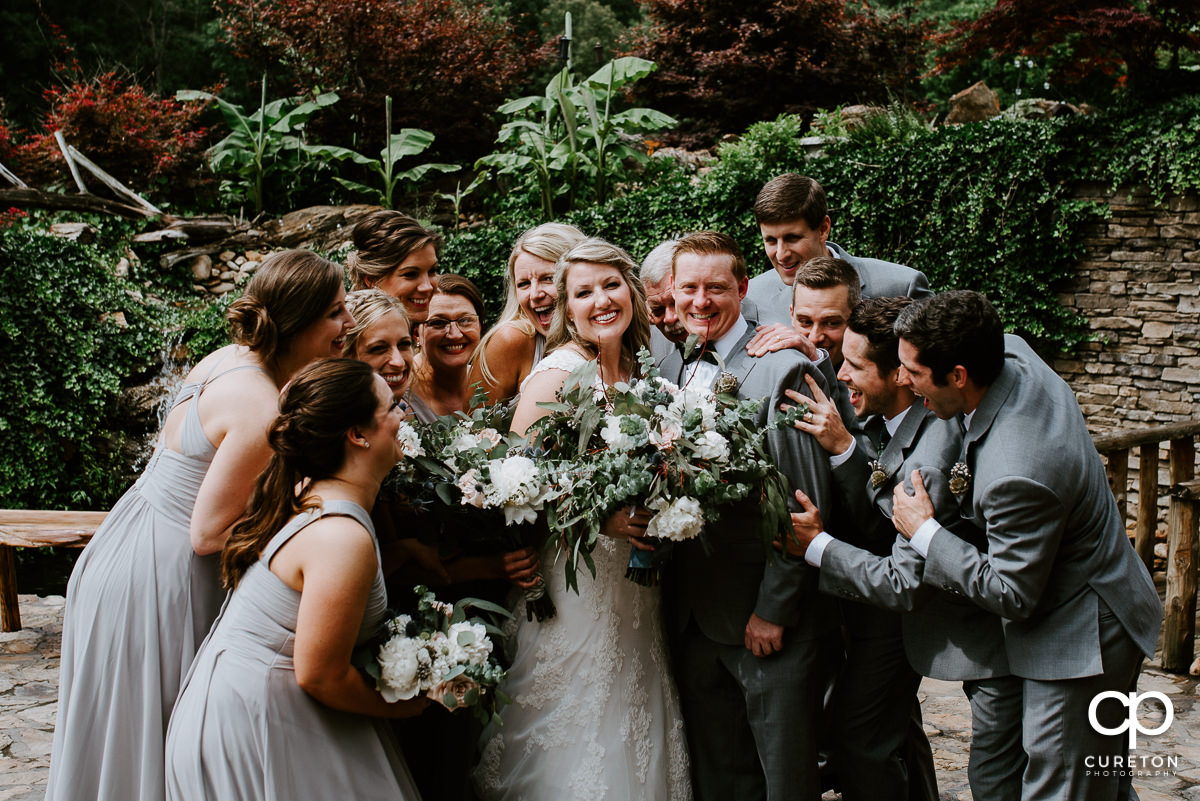 Wedding party hugging the couple before the ceremony at The Hollow at Paris Mountain.