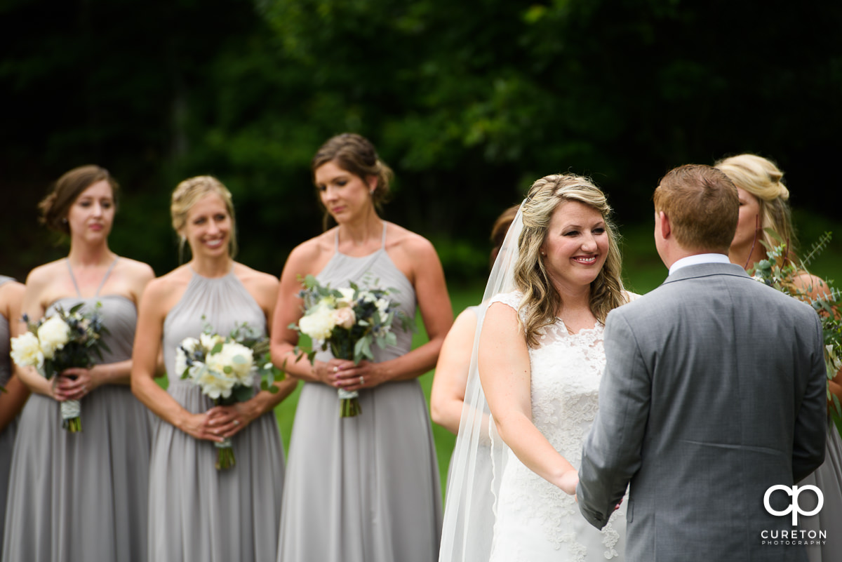 Bride smiling at her groom during the wedding ceremony.