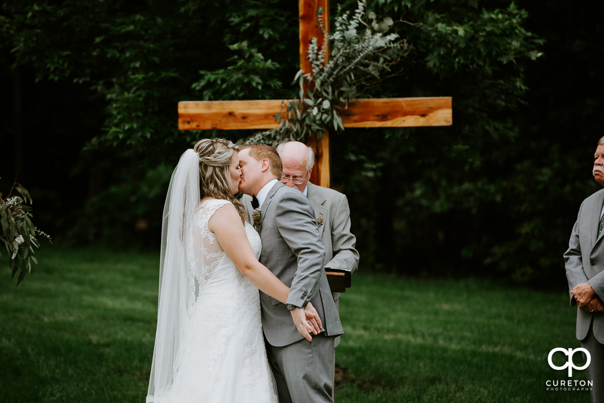 Groom kissing his bride for the first time at the ceremony.