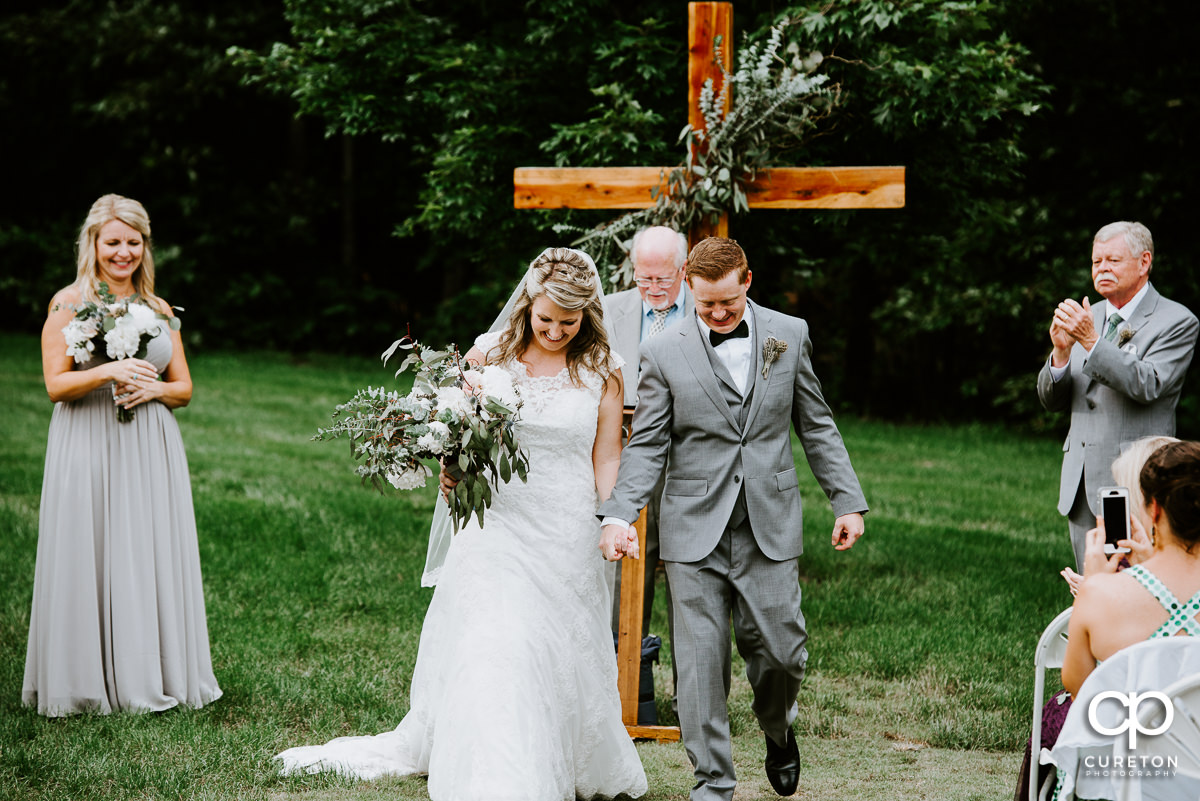 Married couple walking back down the aisle.