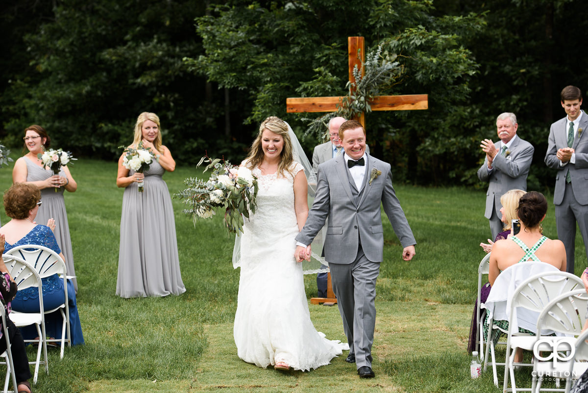 Bride and her groom walking back down the aisle after the wedding.