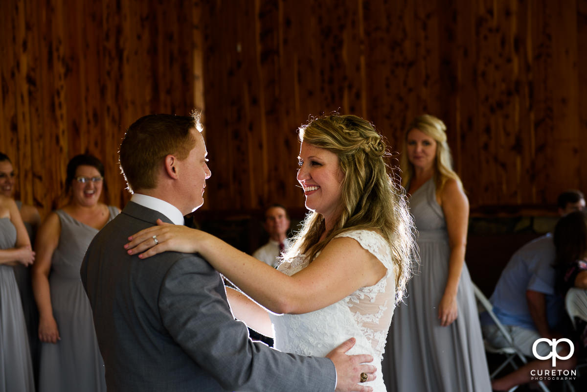 Bride smiling during their first dance at the wedding reception.
