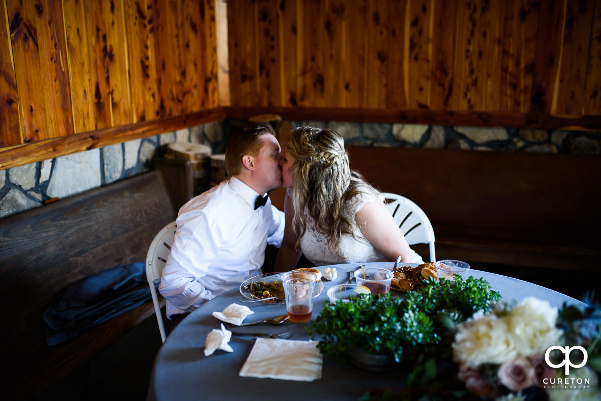 Bride and groom kissing at the reception.