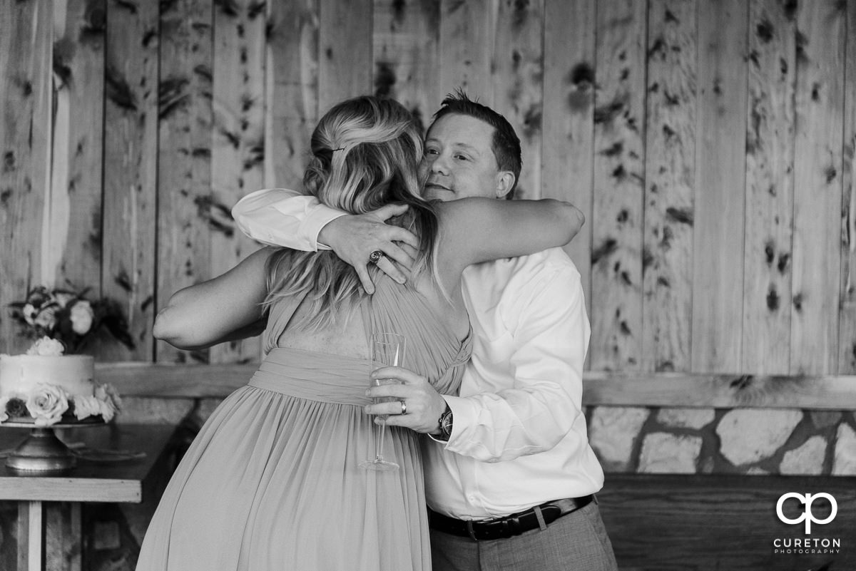 Maid of honor hugging the groom.