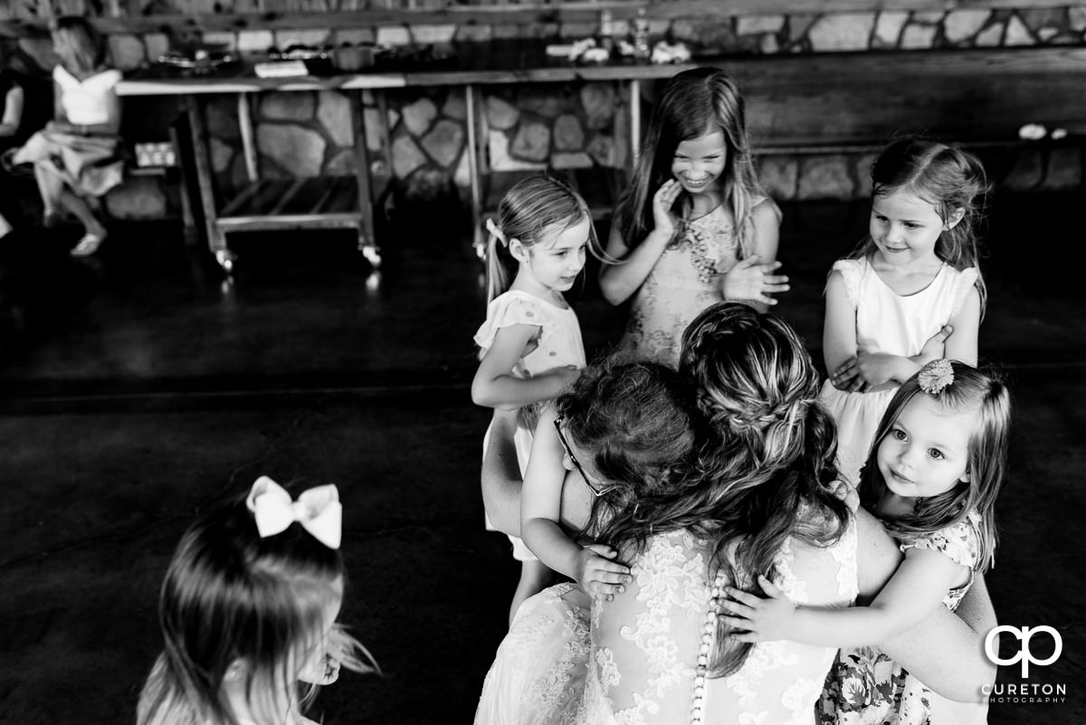 Bride hugging a group of kids.