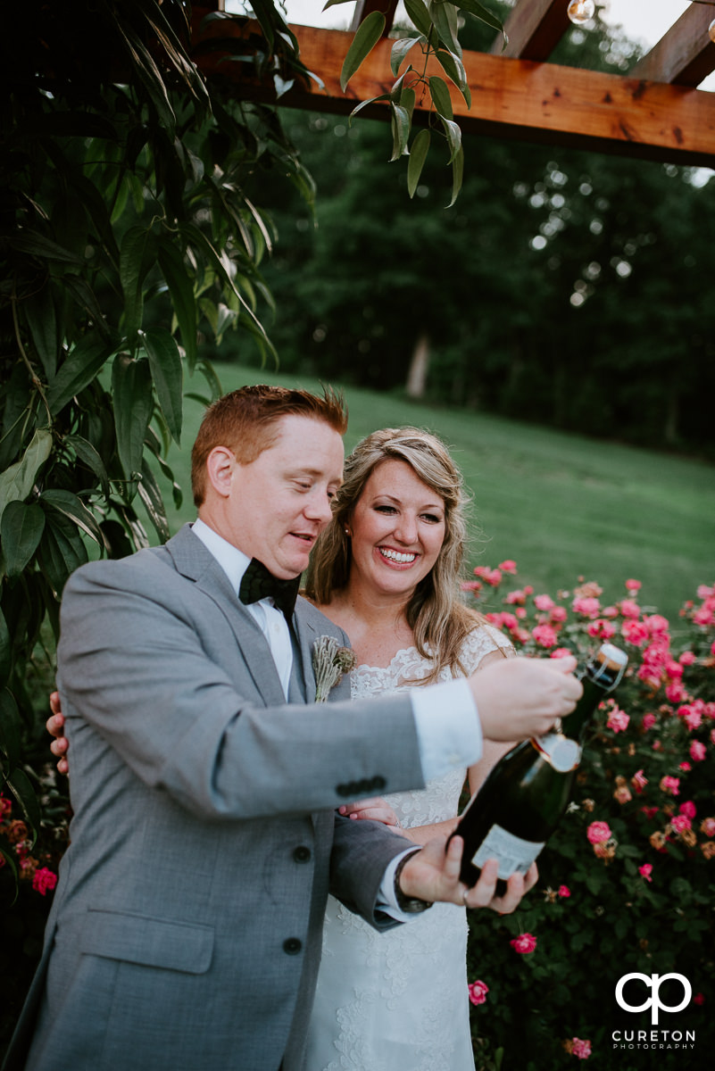 Bride and groom popping open some bubbly.