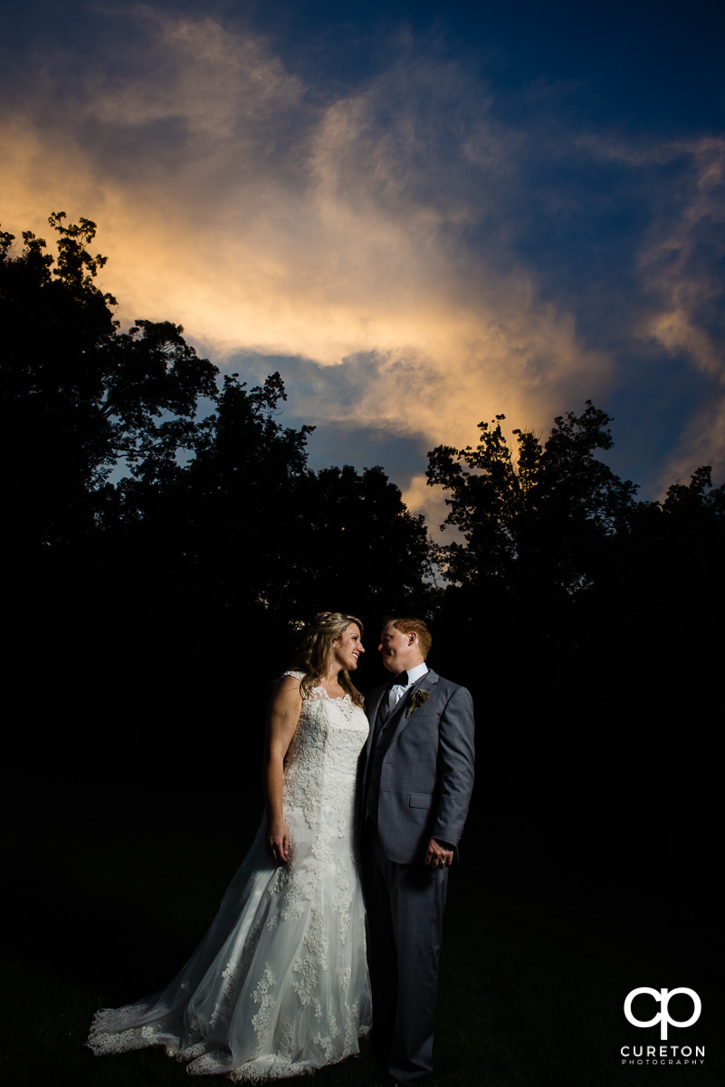 Bride and groom under an amazing sunset at their wedding reception at The Hollow at Paris Mountain in Greenville,SC.