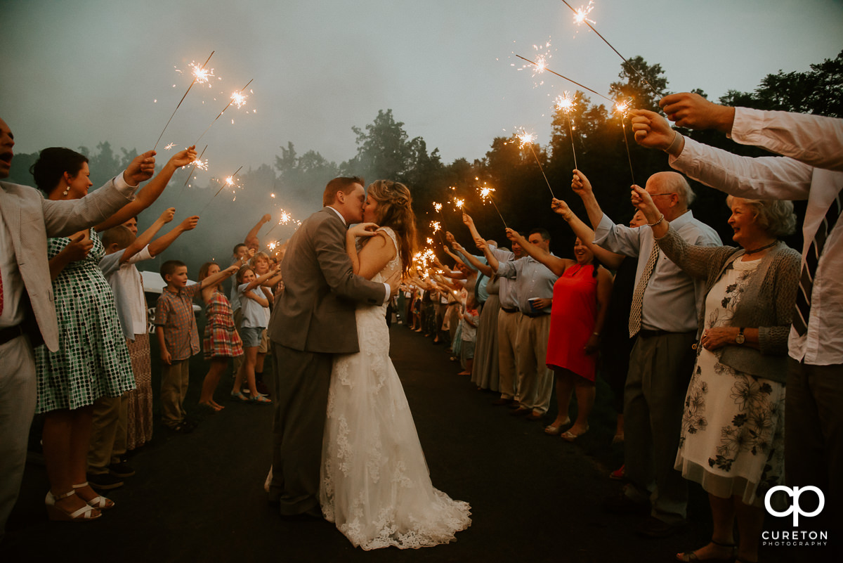 Bride and groom making a grand exit though sparklers.