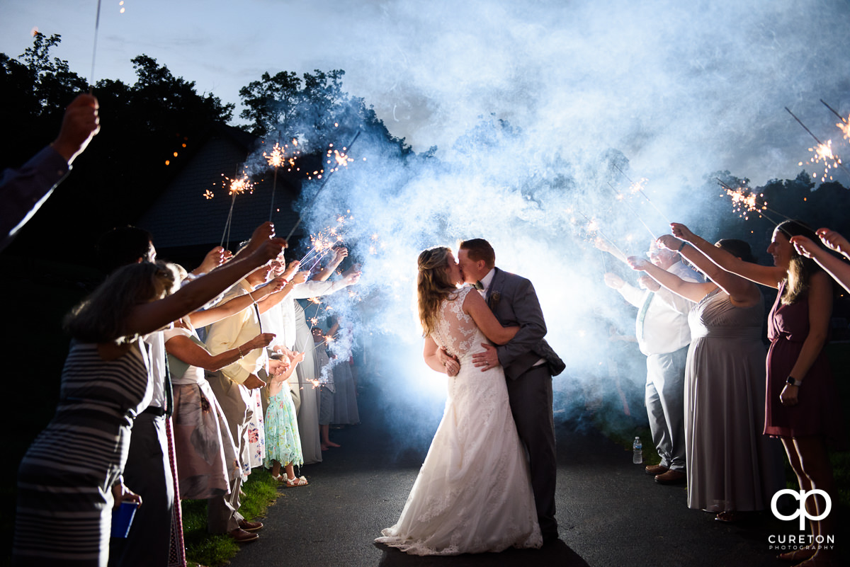 Bride and groom making a grand exit though sparklers at the wedding reception at The Hollow at Paris Mountain.