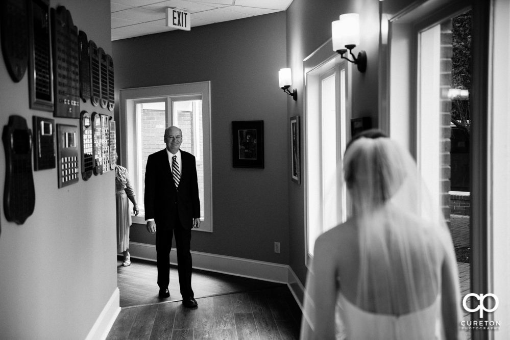 Dad sees his daughter during a first look before the wedding.