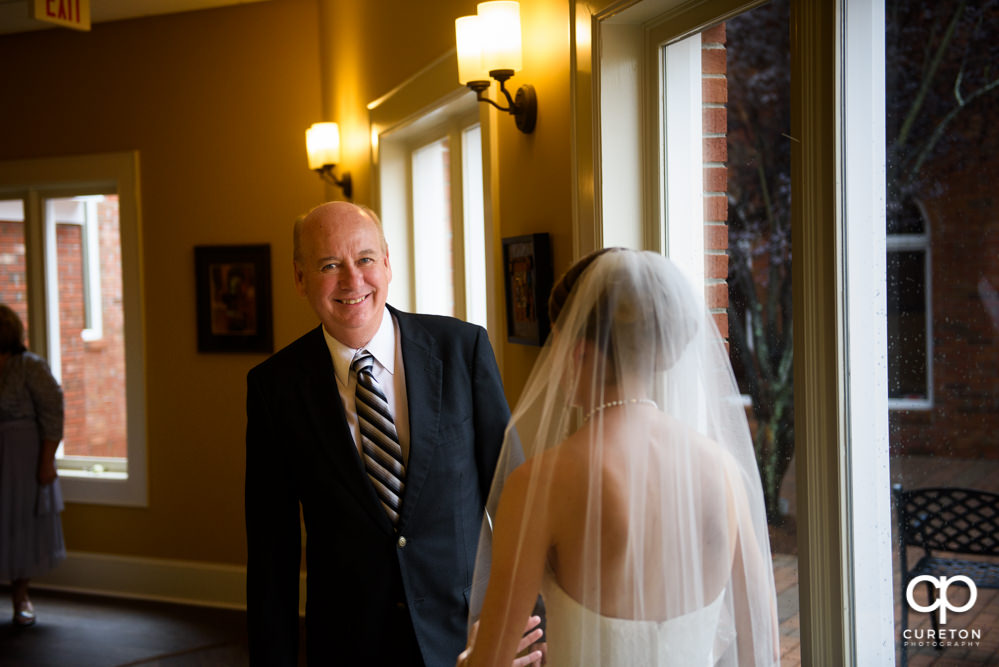 Dad sees his daughter during a first look before the wedding.