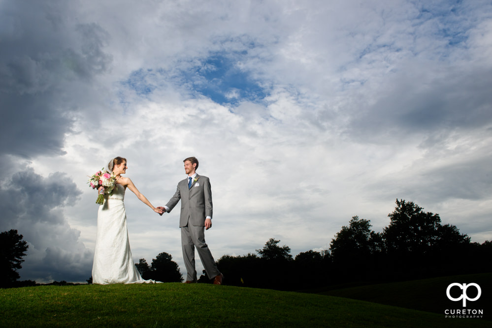 Bride and groom walking on Holly Tree golf course after the wedding.