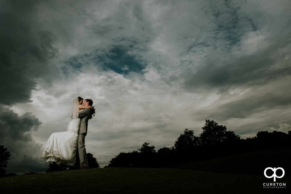 Groom lifting his bride on the golf course at Holly Tree.