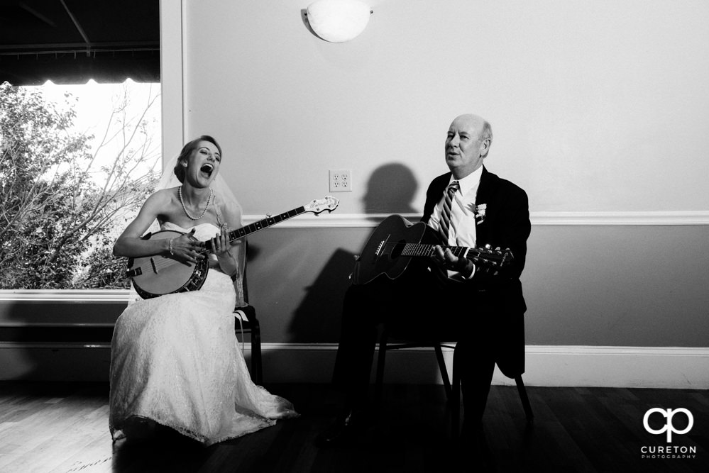 Bride and her father playing guitar and banjo at her wedding reception.