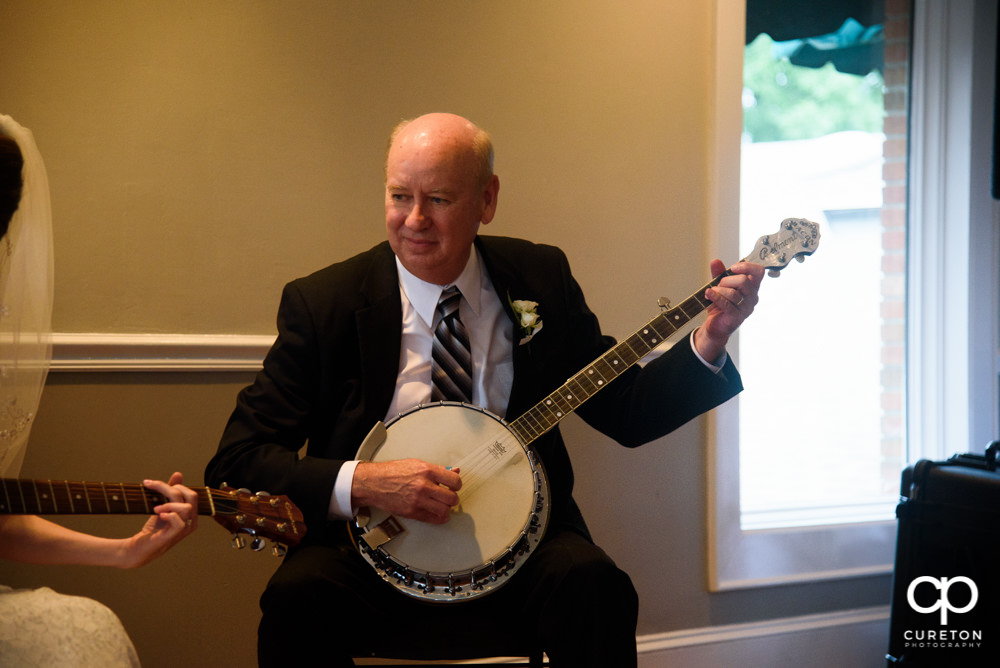Bride and her father playing guitar and banjo at her wedding reception.