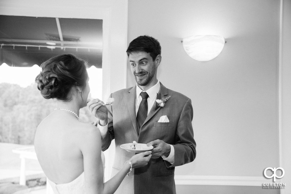Groom feeding the bride cake.