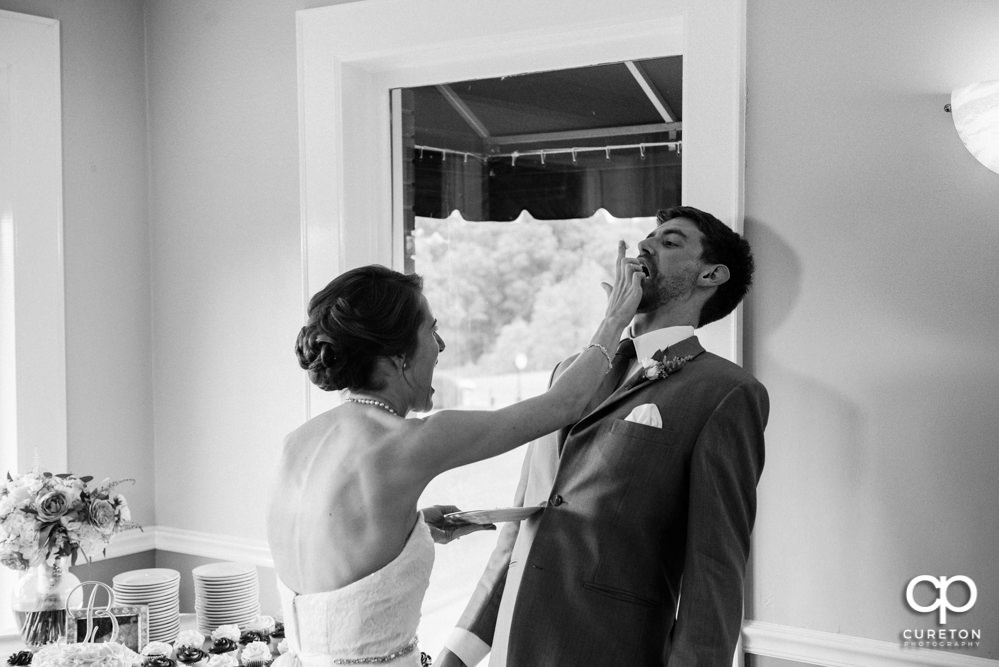 Bride smashing cake onto the groom's face.