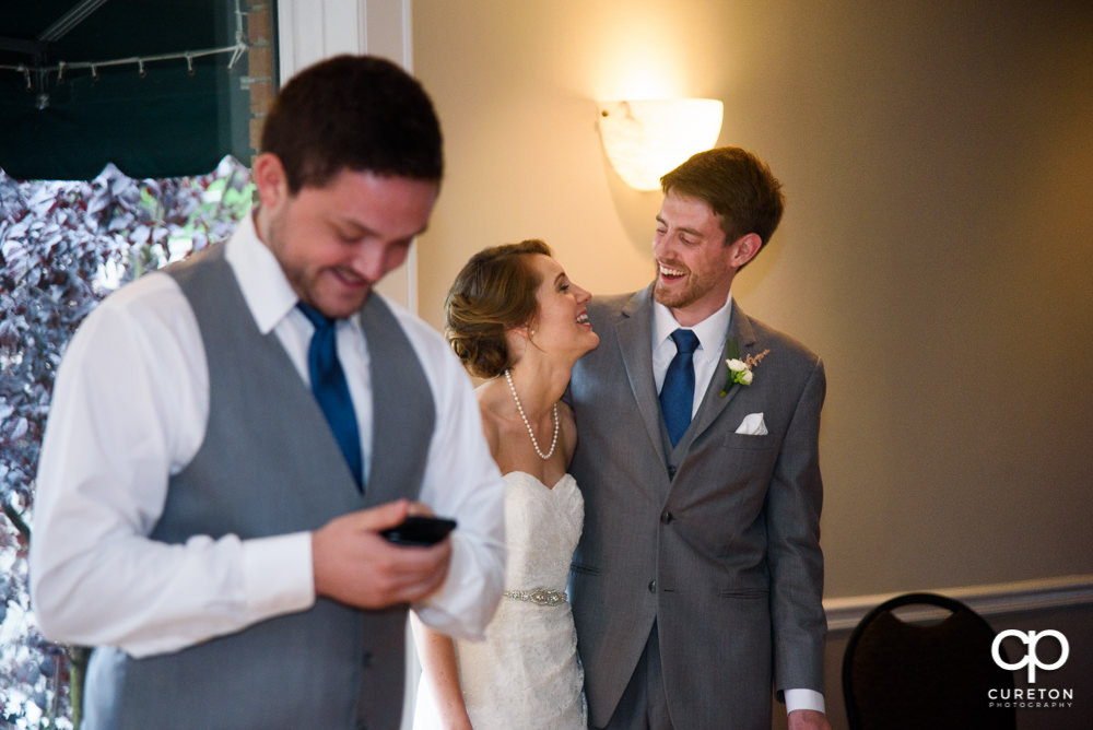 Bride and groom watching as the wedding party gives them a toast.