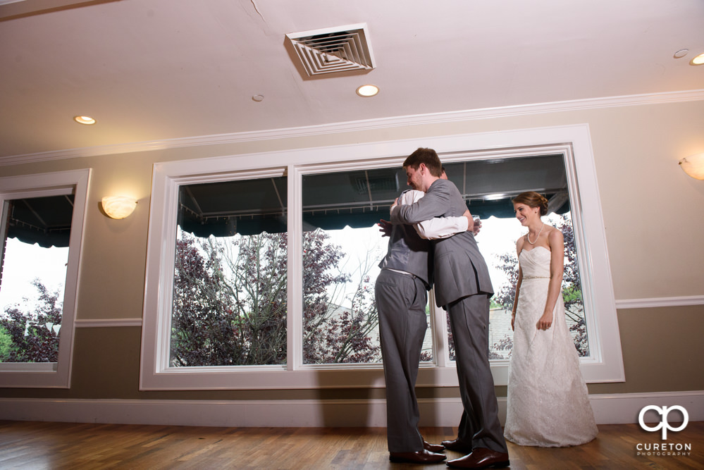 Bride and groom watching as the wedding party gives them a toast.