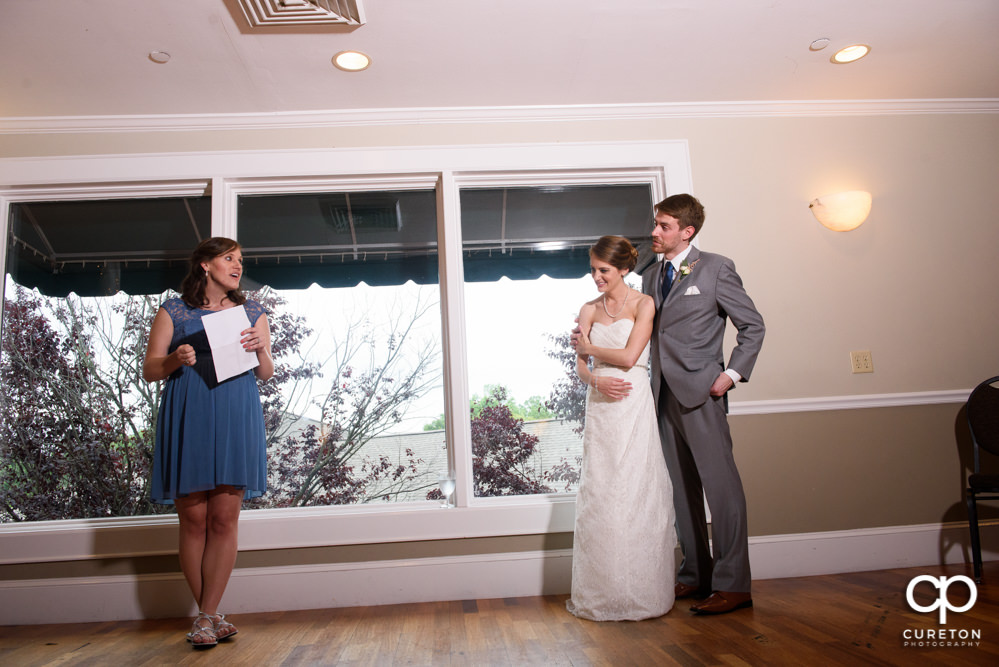 Bride and groom watching as the wedding party gives them a toast.